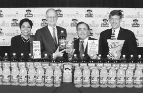 Indra Nooyi (left) and other Pepsi-Co and Quaker Oats executives pose with products from both companies. PepsiCo purchased Quaker Oats in 2001. AP/Wide World Photo. Reproduced by permission.