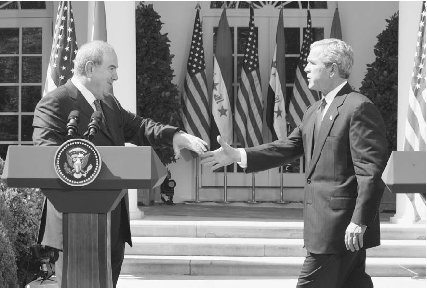 Iyad Allawi and U.S. president George W. Bush shake hands after delivering a press conference at the White House in September 2004. AP/Wide World Photos.
