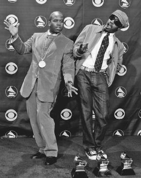 Antwan Patton and Andr Benjamon of OutKast pose in front of the three awards they won at the 2004 Grammy Awards. AP/Wide World Photos. Reproduced by permission.