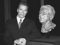 Arnold Schwarzenegger poses with a bronze bust of President Ronald Reagan. Mike Guastella/WireImage.com.